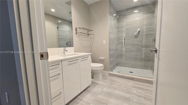 bathroom featuring vanity, toilet, and a shower with door