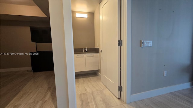 corridor featuring sink and light hardwood / wood-style floors