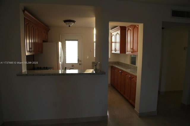 kitchen with refrigerator and kitchen peninsula