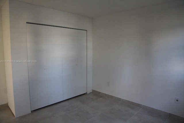 unfurnished bedroom with light tile patterned floors and a closet