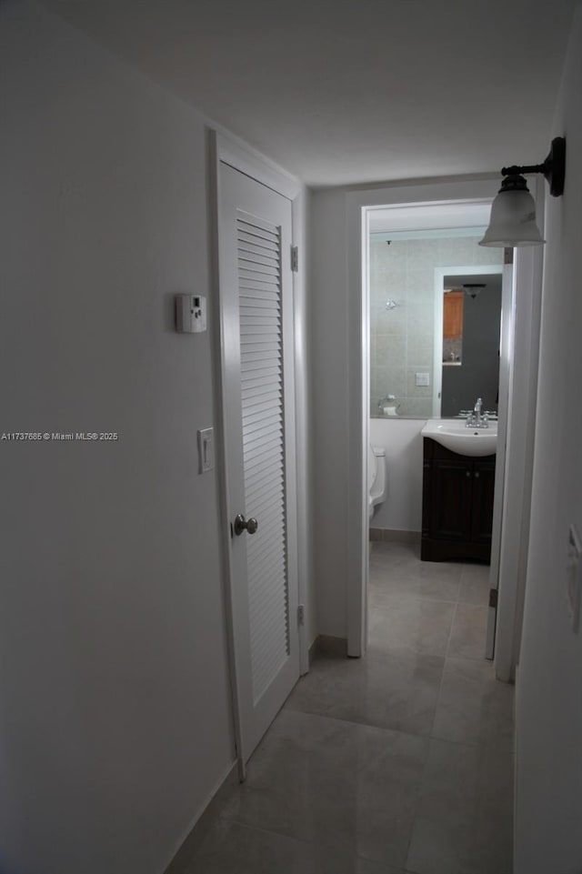 hallway with sink and light tile patterned floors