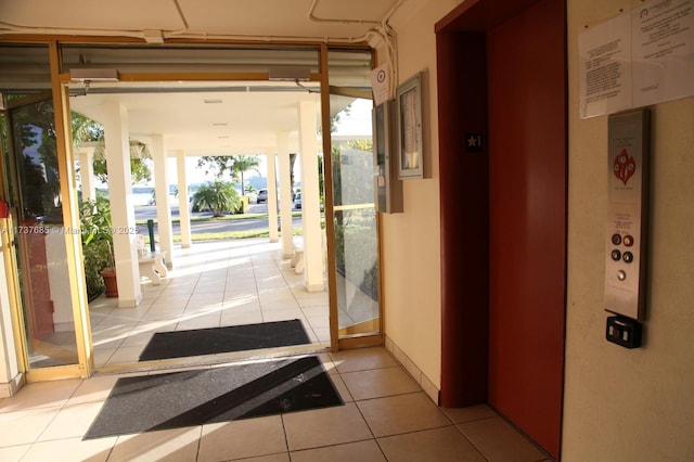 doorway to outside with light tile patterned flooring