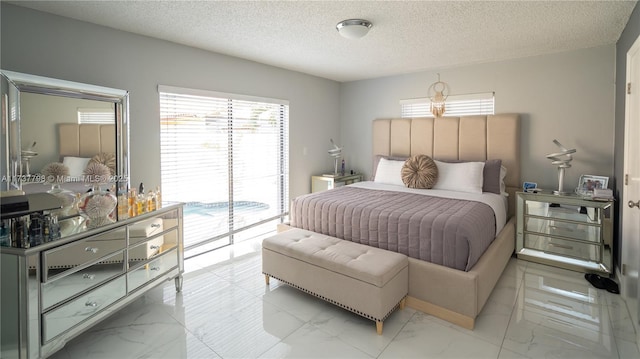 bedroom featuring access to exterior and a textured ceiling