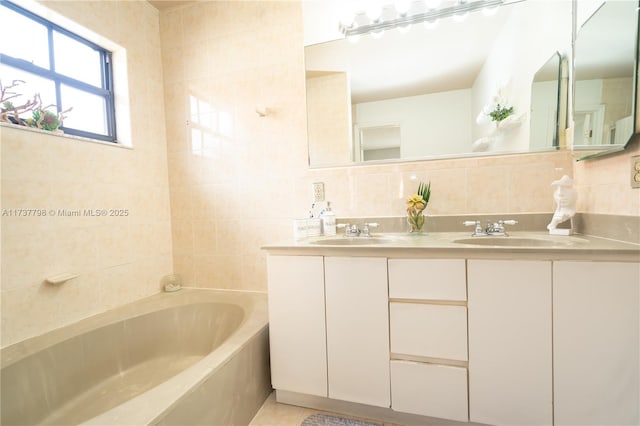 bathroom with vanity, tile walls, a bathtub, and decorative backsplash