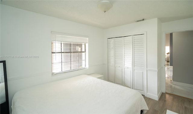 bedroom featuring wood-type flooring and a closet