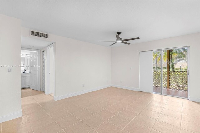 spare room with ceiling fan and light tile patterned floors