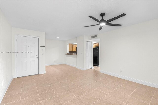 unfurnished living room featuring ceiling fan and light tile patterned floors