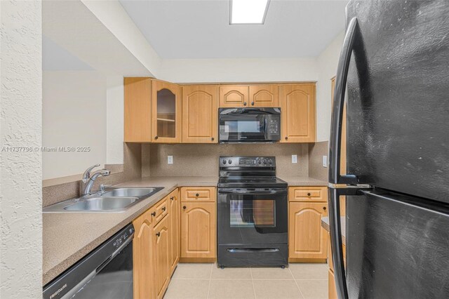 kitchen with sink, light tile patterned floors, black appliances, and decorative backsplash