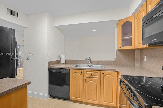 kitchen featuring sink, backsplash, black appliances, and light tile patterned floors