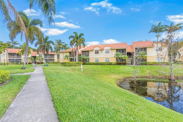 view of community with a lawn and a water view