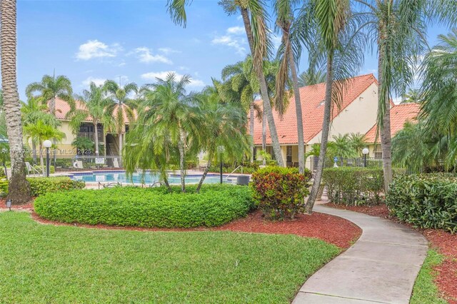 view of property's community featuring a swimming pool and a lawn