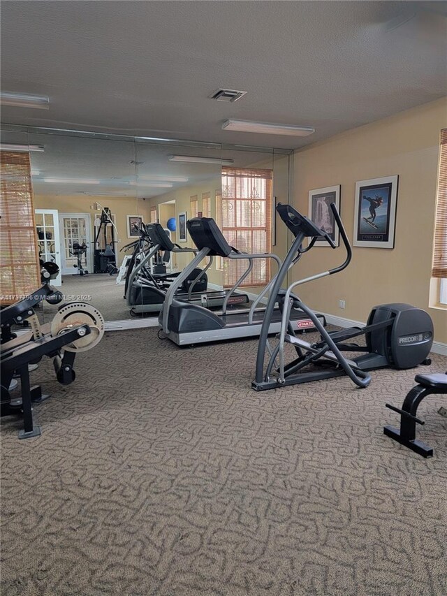 gym featuring carpet and a textured ceiling