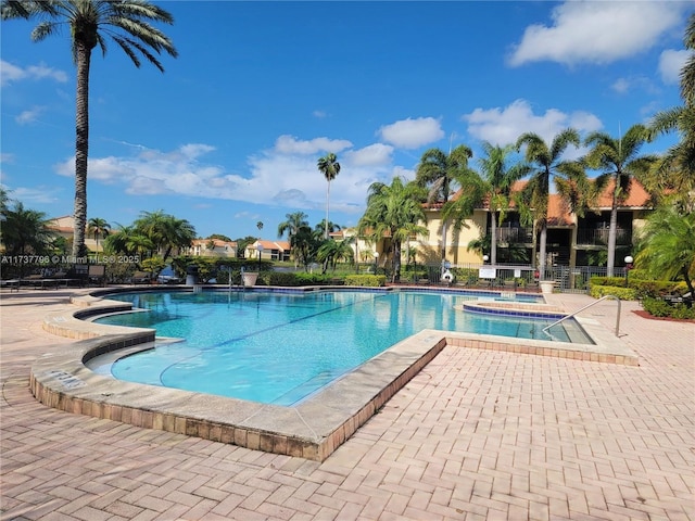 view of swimming pool featuring a jacuzzi and a patio