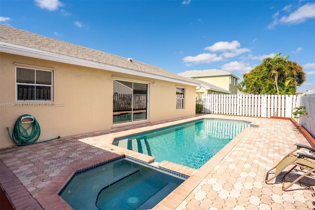 view of pool with a fenced backyard and a pool with connected hot tub