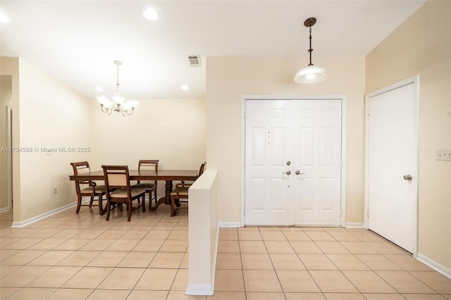 entryway featuring a chandelier, light tile patterned flooring, visible vents, and baseboards