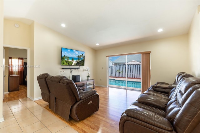 living area with lofted ceiling, light tile patterned floors, a wealth of natural light, and recessed lighting