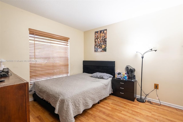 bedroom featuring baseboards and wood finished floors