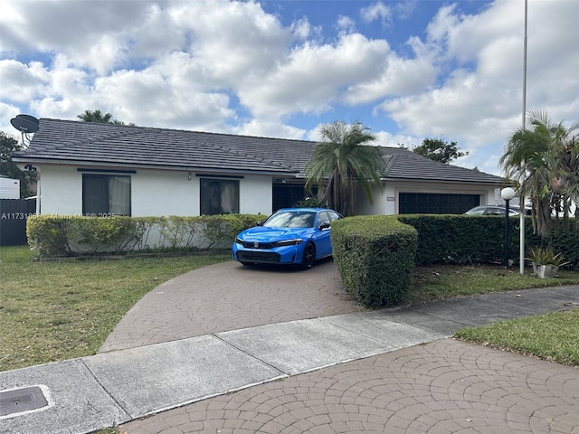 ranch-style home with a garage and a front lawn