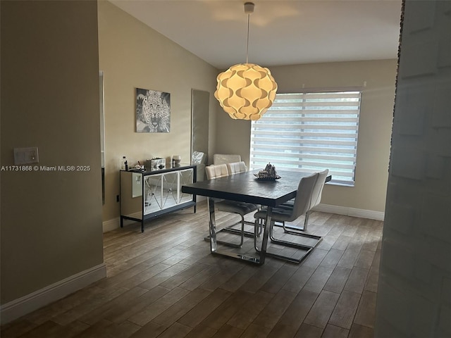 dining area with dark wood-type flooring and lofted ceiling