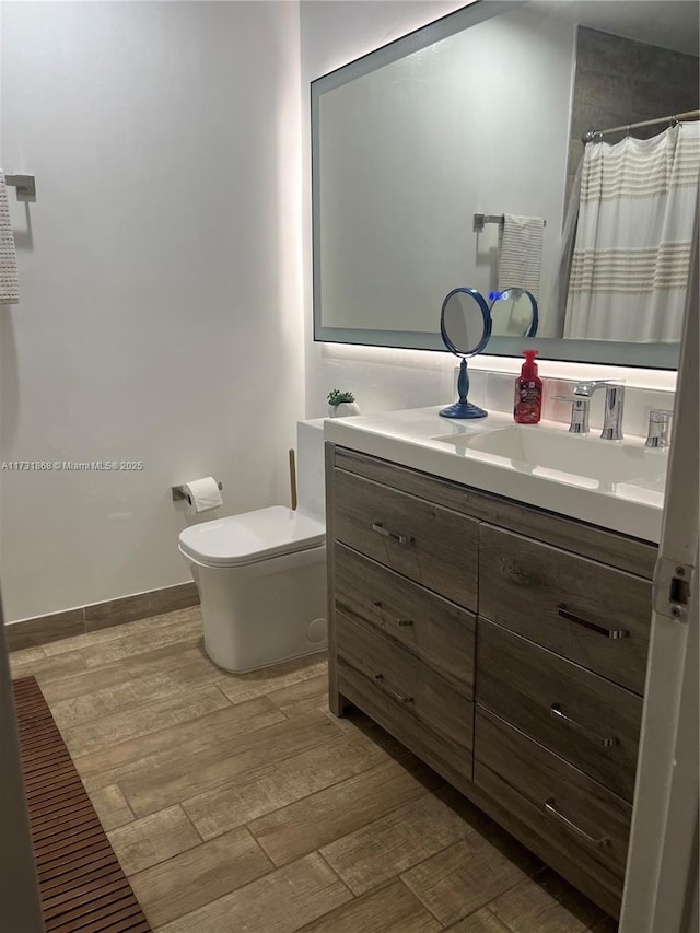 bathroom with toilet, vanity, a shower with shower curtain, and wood-type flooring