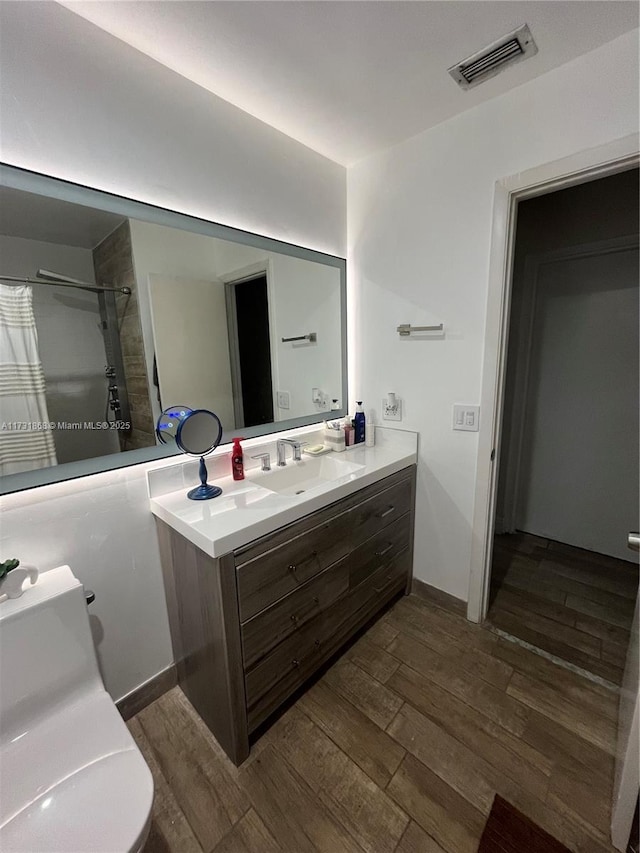 bathroom featuring wood-type flooring, vanity, and walk in shower