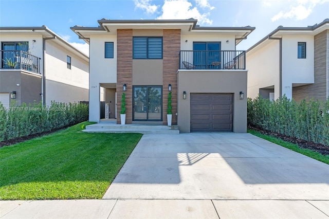 view of front of house featuring a garage, a front yard, french doors, and a balcony