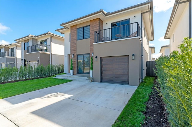 view of front of property with a balcony, a garage, and a front yard