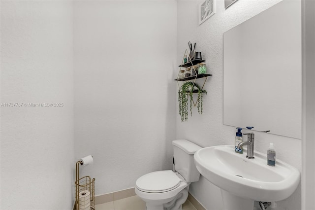 bathroom featuring tile patterned floors, toilet, and sink