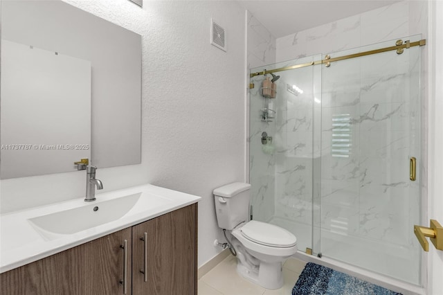 bathroom with vanity, tile patterned flooring, toilet, and walk in shower