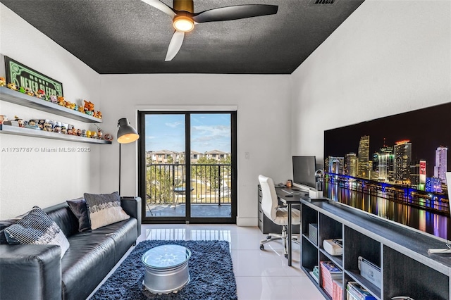 tiled office space featuring ceiling fan and a textured ceiling