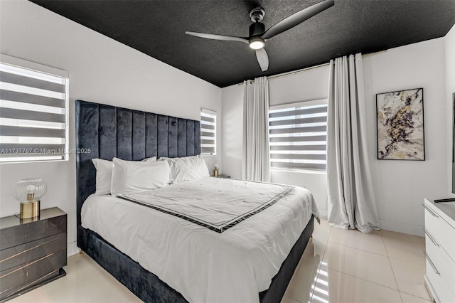 bedroom with light tile patterned floors, a textured ceiling, and ceiling fan