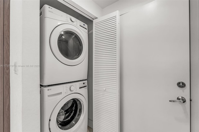 clothes washing area featuring stacked washing maching and dryer