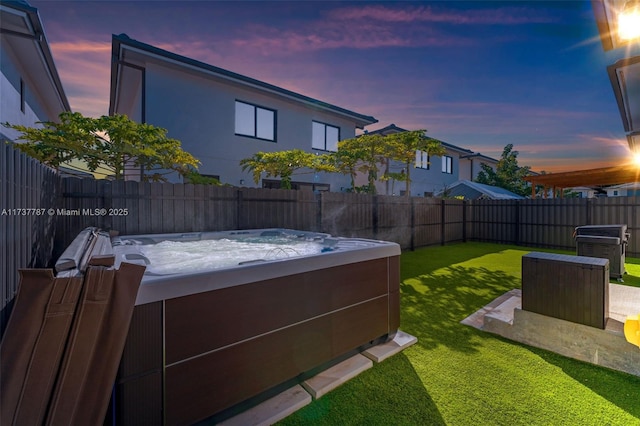 yard at dusk with a hot tub