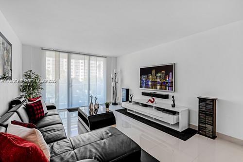 living room featuring floor to ceiling windows and light tile patterned floors