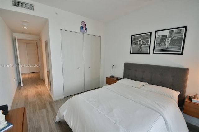 bedroom with light hardwood / wood-style floors and a closet