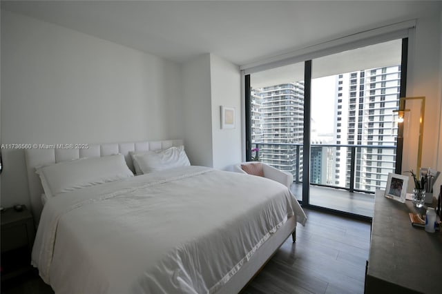 bedroom with dark wood-type flooring and floor to ceiling windows