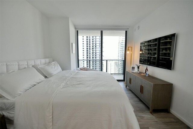 bedroom featuring wood-type flooring and a wall of windows