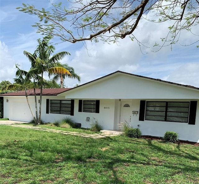 ranch-style house with a garage and a front lawn