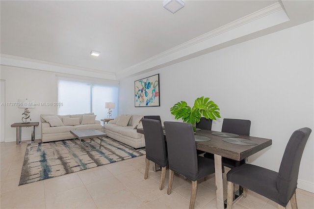 tiled dining space featuring ornamental molding