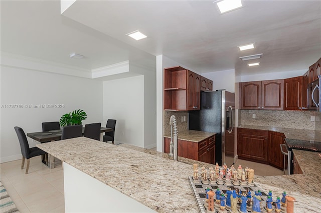 kitchen featuring stainless steel appliances, tasteful backsplash, light tile patterned flooring, and kitchen peninsula