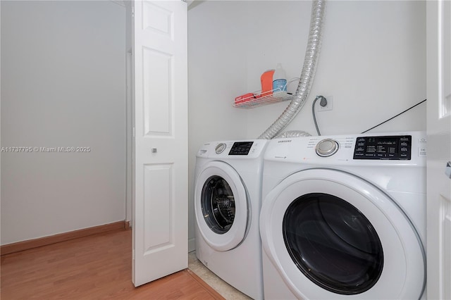 laundry area with separate washer and dryer and light hardwood / wood-style flooring