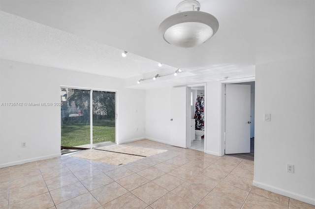 tiled spare room featuring a textured ceiling