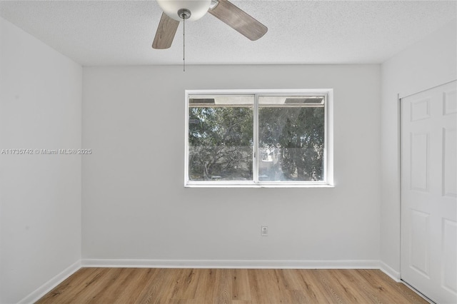 unfurnished room with ceiling fan, wood-type flooring, and a textured ceiling