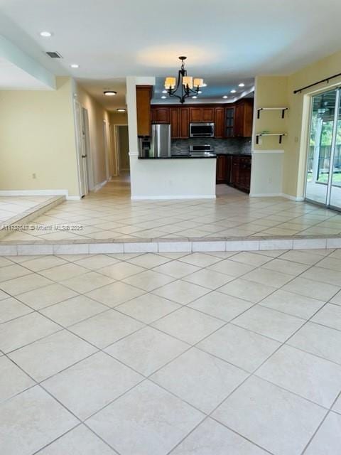 kitchen featuring hanging light fixtures, light tile patterned flooring, appliances with stainless steel finishes, and an inviting chandelier