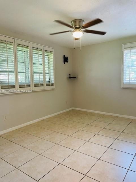 spare room with ceiling fan and light tile patterned flooring