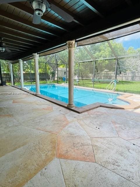 view of pool featuring ceiling fan, glass enclosure, and a patio