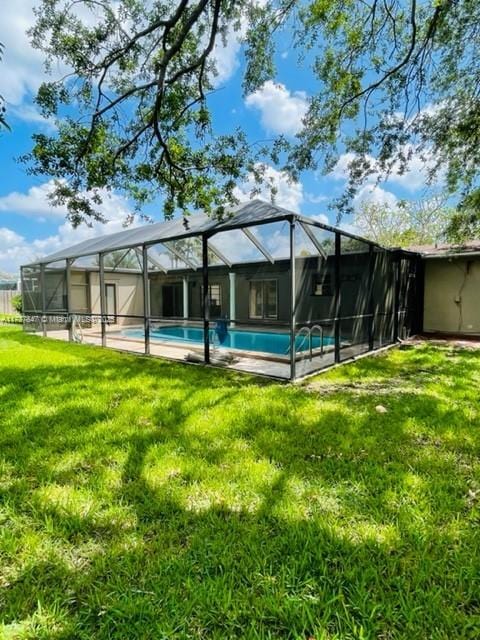 view of swimming pool with a lanai and a yard