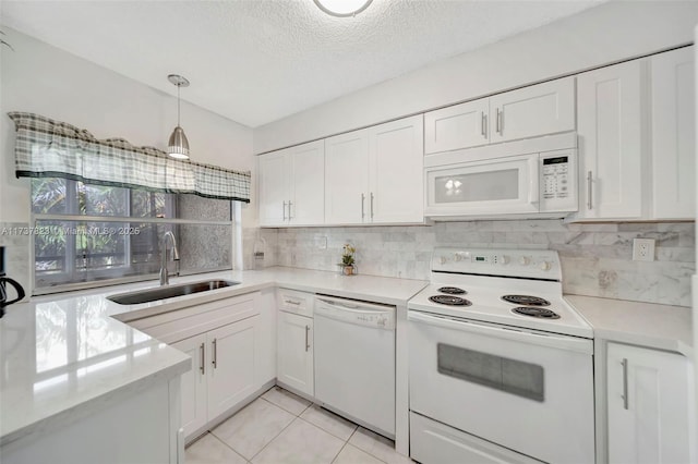 kitchen with sink, white cabinets, white appliances, and decorative light fixtures