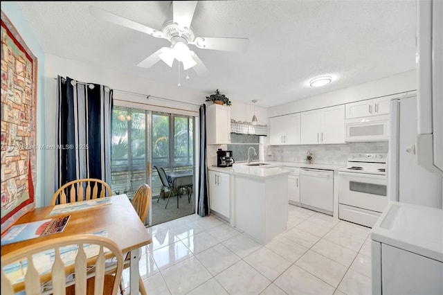 kitchen with pendant lighting, white cabinets, decorative backsplash, light tile patterned floors, and white appliances