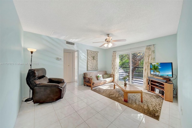 living room with light tile patterned floors, a textured ceiling, and ceiling fan